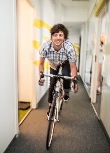 The marketing specialist of Xfive Agency rides his bike at the company's office corridor.