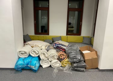 Operations room at Xfive office in Krakow with blankets, sheets, and towels prepared for refugees.
